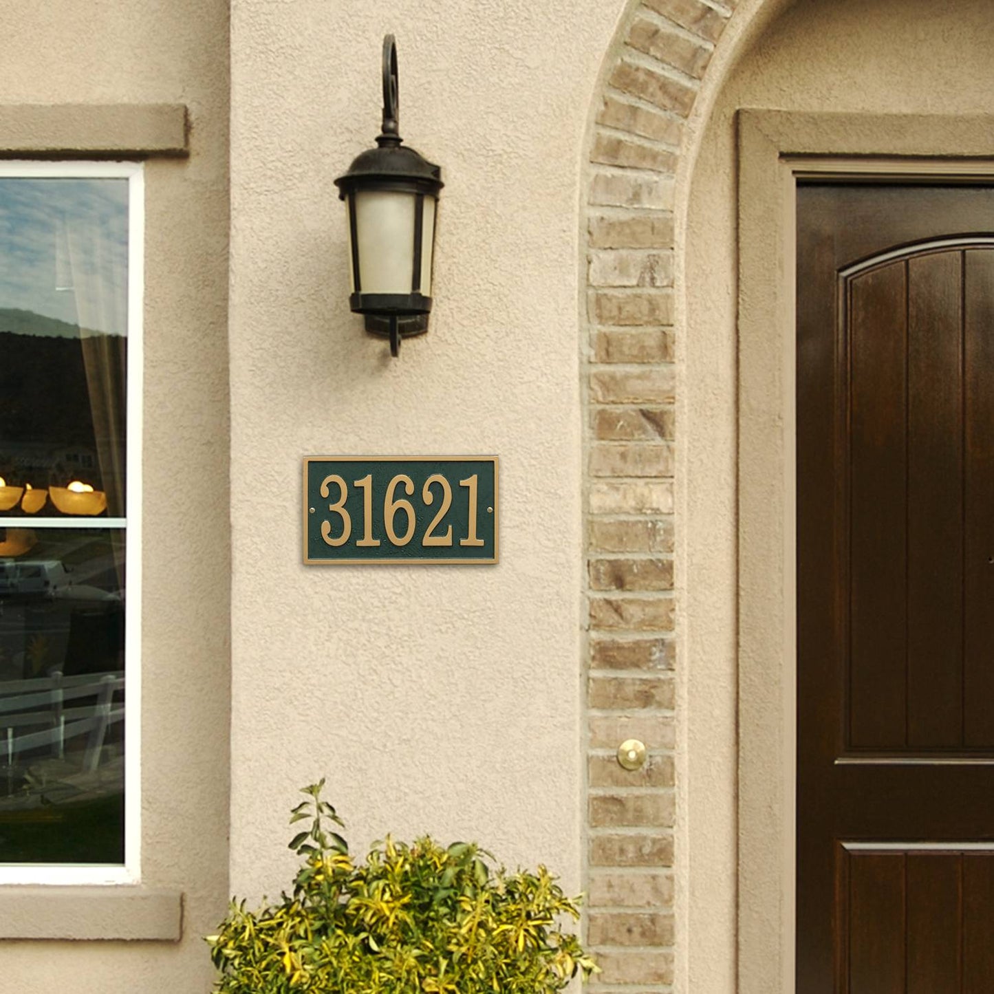 Green and gold rectangular address plaque with raised numbers mounted beside a dark wood door and beige stucco wall, handcrafted in USA, featured in Home & Decor, Mailboxes and Address Signs, Best Sellers, and Promo Eligible collections.