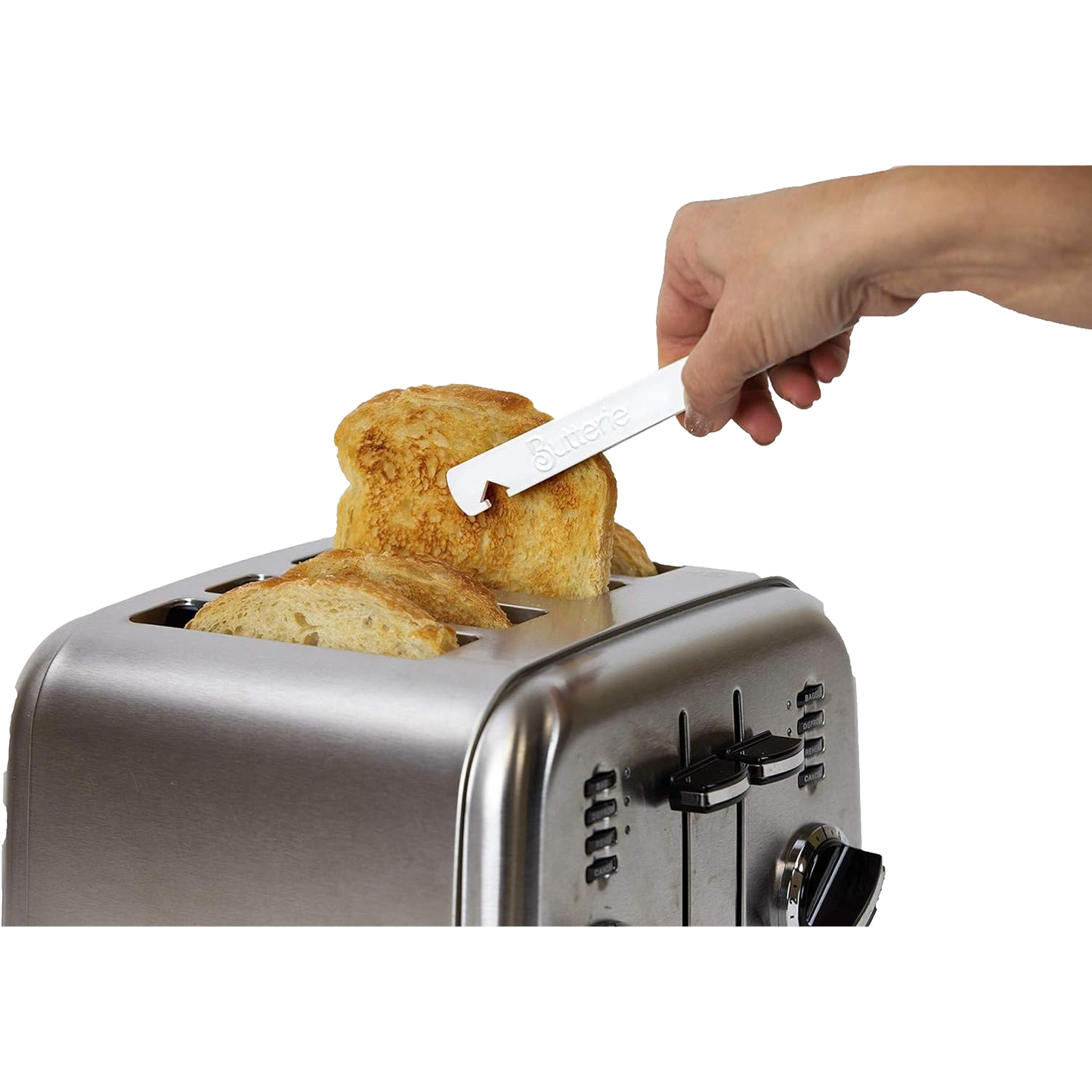 Hand using white Butterie toaster tong with serrated teeth and oven rack hook to safely lift toasted bread from stainless steel toaster, featured in kitchen gadgets and accessories collections.