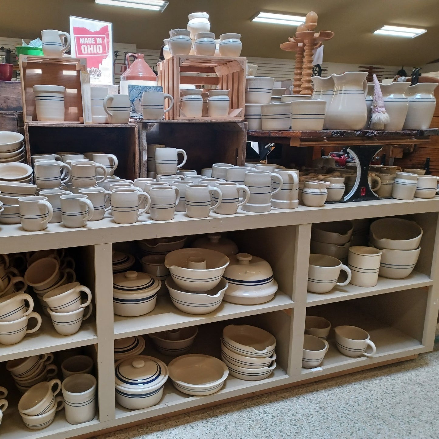 Shelves filled with handcrafted stoneware crocks, mugs, bowls, and pitchers in neutral tones, perfect for Kitchen & Food, Food Preservation, and USA Made collections.