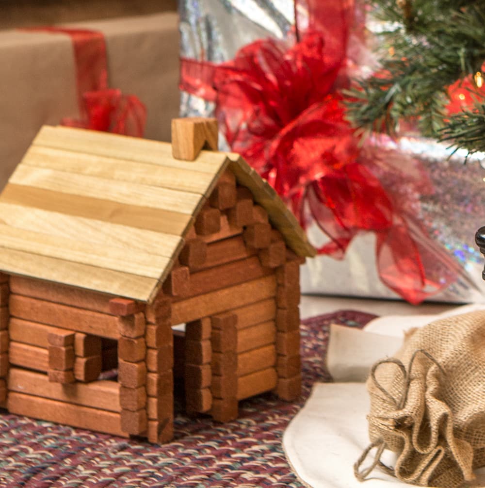 Handcrafted Amish made wooden log structure displayed indoors with holiday gifts and festive decor, showcasing durable hardwood toy for indoor play and children's imaginative building fun.