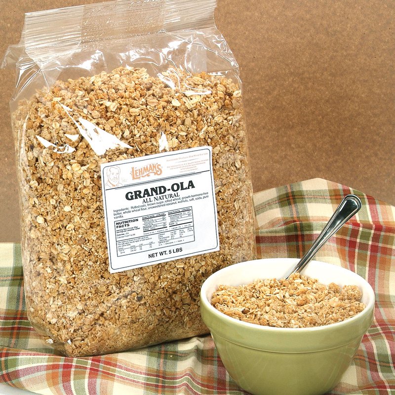 Clear plastic package of handcrafted all-natural Amish made granola alongside a green bowl filled with crunchy granola and a spoon, set on a plaid cloth in a kitchen and food setting for Pantry, Snacks and Sweets, USA Made, and Best Sellers collections.