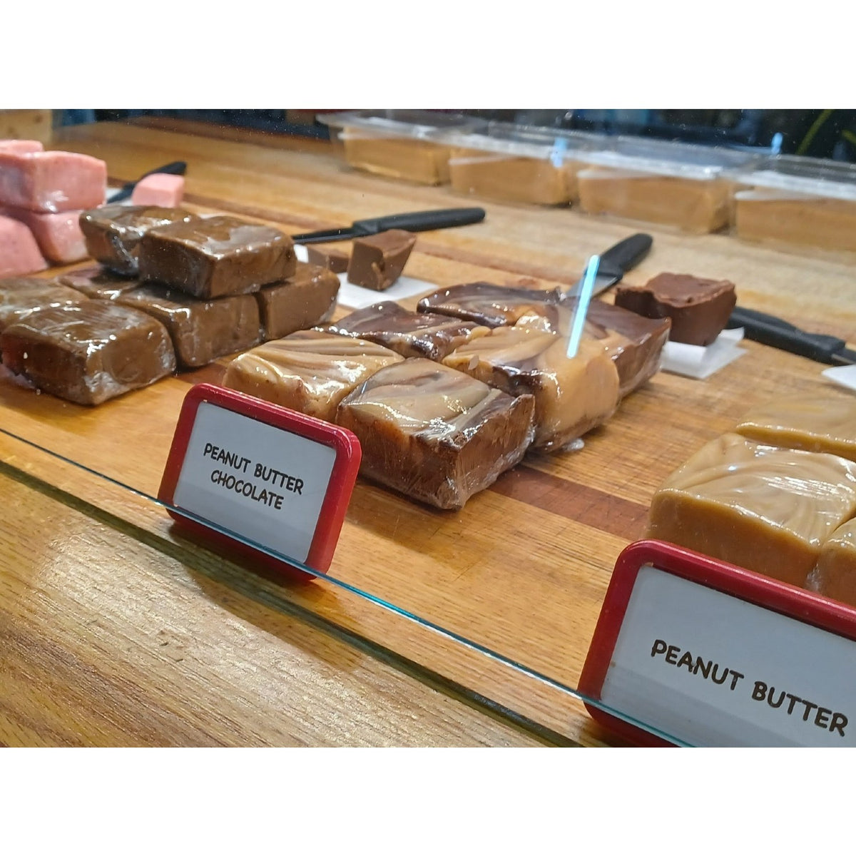 Handcrafted creamy peanut butter chocolate and peanut butter fudge squares displayed on a wooden counter, featured in Kitchen & Food, Food, Snacks and Sweets, USA Made, Best Sellers, and Promo Eligible collections.