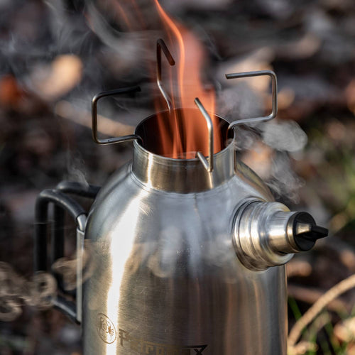 Flames and smoke rising from the top of a stainless steel outdoor fire kettle with metal pot supports and a screw-on spout, designed for Farm, Garden & Tool, Camping, Emergency Supplies, and Best Sellers collections.