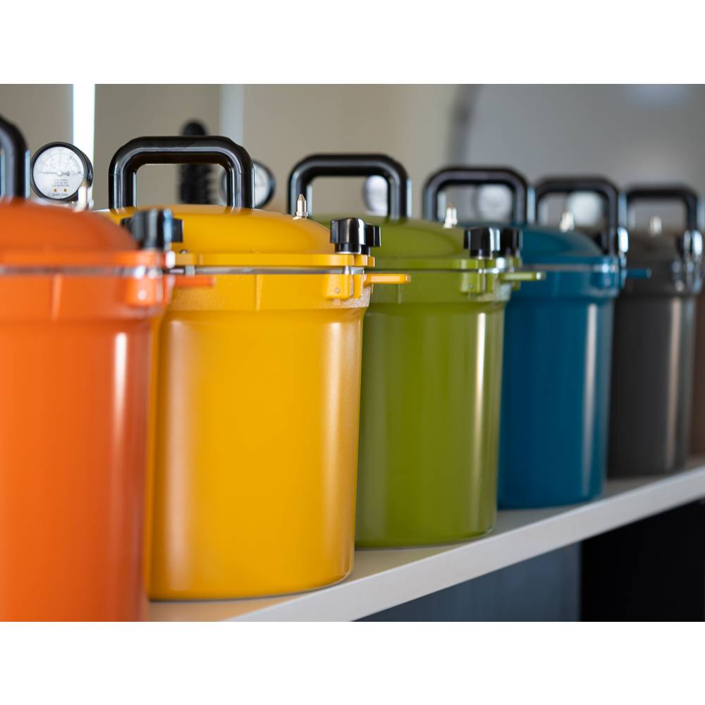 Row of colorful 21.5-quart pressure canners with secure locking lids and sturdy handles, featuring vibrant finishes ideal for Kitchen & Food, Food Preservation, and USA Made collections.