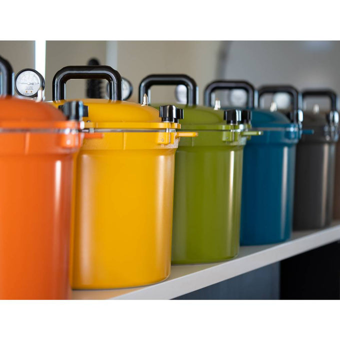 Row of colorful 21.5-quart pressure canners with secure locking lids and sturdy handles, featuring vibrant finishes ideal for Kitchen & Food, Food Preservation, and USA Made collections.