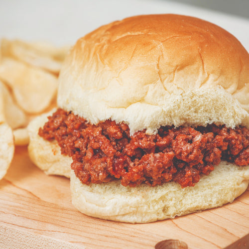Close-up of a handcrafted sandwich filled with seasoned ground beef on a soft bun, served with potato chips, perfect for Kitchen & Food, Food, Meats, Best Sellers, and Promo Eligible collections.