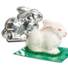 Handcrafted metal bunny cake pan next to a decorated 3D bunny cake with white frosting and green grass detail, featured in Kitchen & Food, Cookware, Baking Supplies, USA Made collections.