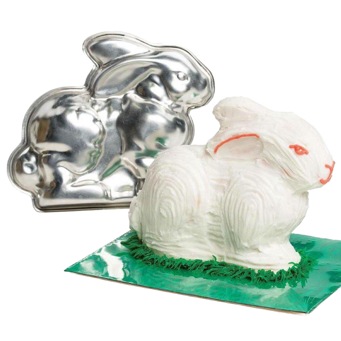 Handcrafted metal bunny cake pan next to a decorated 3D bunny cake with white frosting and green grass detail, featured in Kitchen & Food, Cookware, Baking Supplies, USA Made collections.