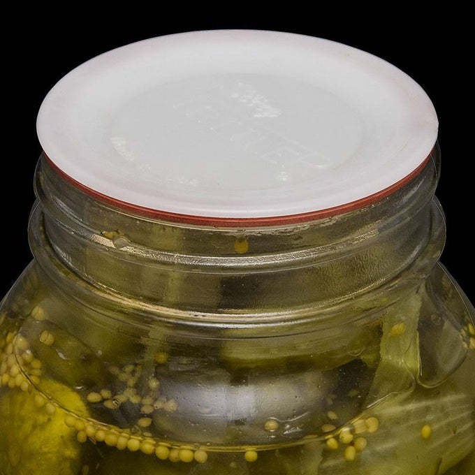 Close-up of a handcrafted reusable plastic lid with an orange sealing ring on a glass jar of pickles, ideal for Kitchen & Food, Food Preservation, Canning, and USA Made collections.