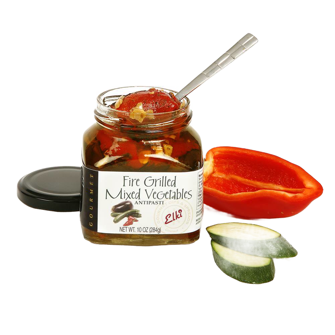 Open jar of fire-grilled mixed vegetables antipasti with a spoon inside, presented alongside sliced zucchini and halved red bell pepper, ideal for Kitchen & Food, Food, Pantry, Best Sellers, and Promo Eligible collections.