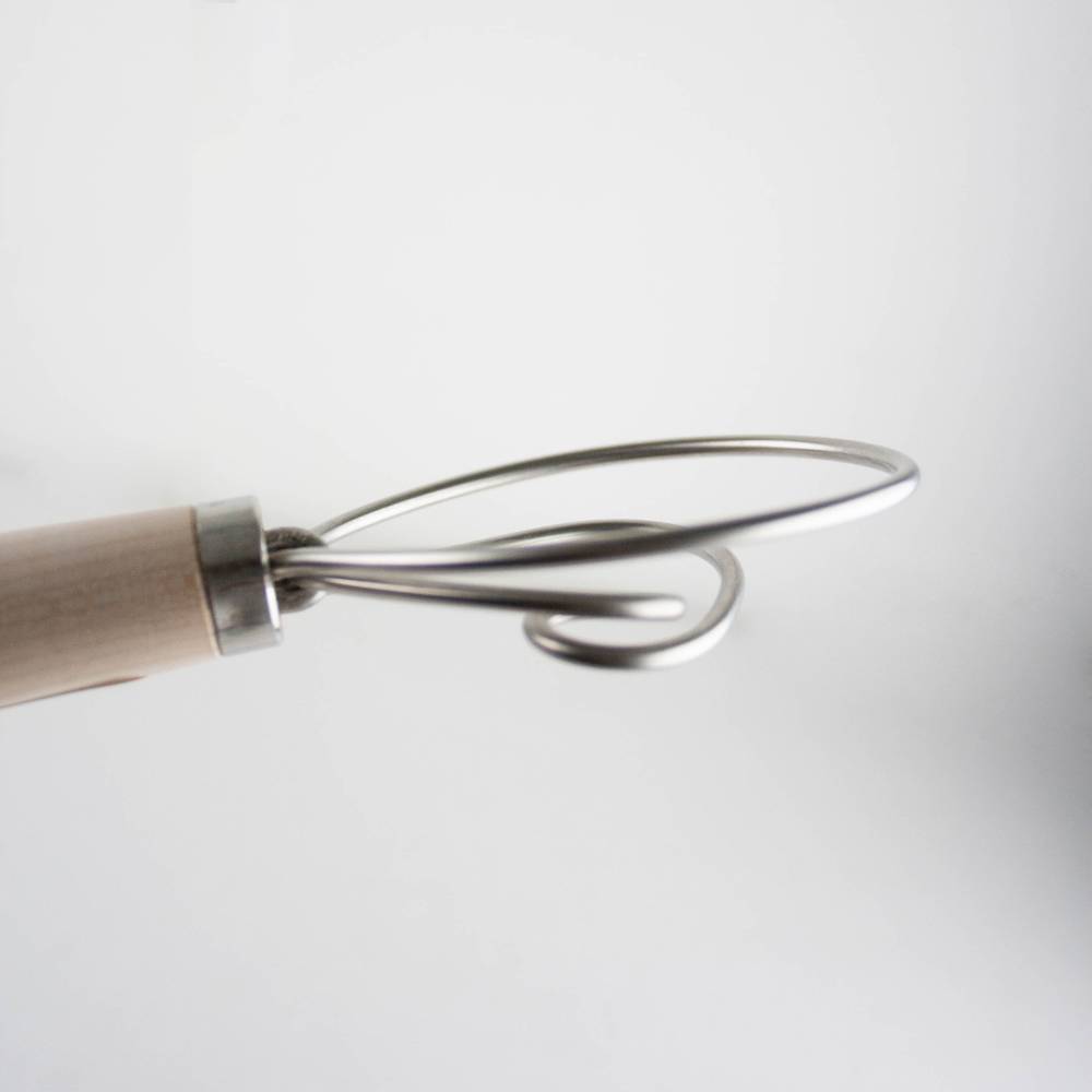 Close-up of a handcrafted Amish made dough whisk with two spiral stainless steel wires and a smooth wooden handle, ideal for baking and kitchen gadgets collections.