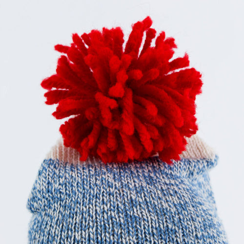 Close-up of a hand-sewn blue knit hat topped with a bright red pom-pom, handcrafted in the USA, featured in Toys, Books & Games, USA Made, Children's Toys, Indoor Play, and Best Sellers collections.
