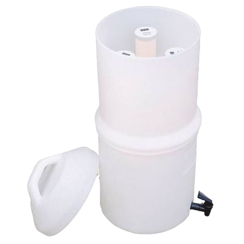 White plastic water filter housing with cylindrical replacement elements inside and a removable lid, designed for tabletop use in emergency and water treatment applications.