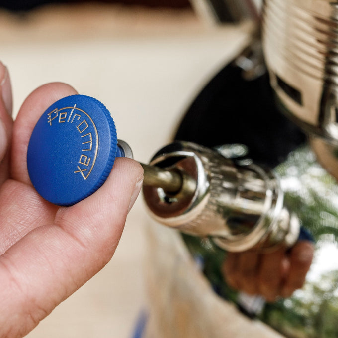 Hand turning a chrome pump with a blue knob engraved with Petromax logo, designed for use with lamps, featured in Lamps & Lighting, Parts and Accessories, Other Parts, Best Sellers, and Promo Eligible collections.