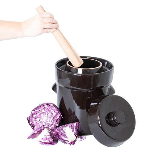 Glossy black stoneware crock with matching lid and wooden stomper in use, shown alongside fresh cut purple cabbage, handcrafted and ideal for Kitchen & Food, Food Preservation, Fermenting and Pickling, Best Sellers, and Promo Eligible collections.
