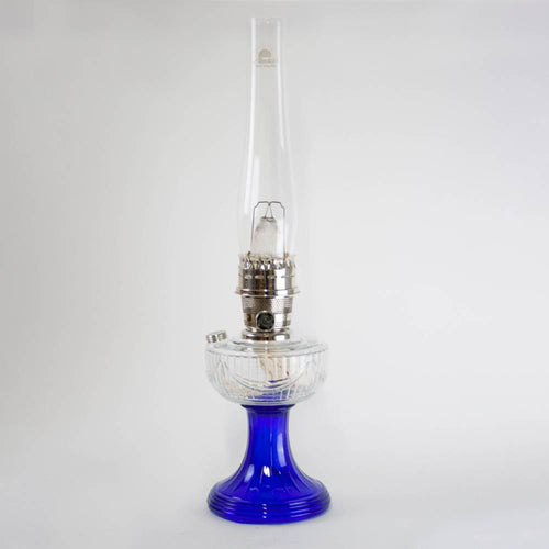 Handcrafted oil lamp featuring a vibrant cobalt glass base and clear glass chimney with brass trim, ideal for Lamps & Lighting, Oil Lamps, Table Lamps, Best Sellers, and Promo Eligible collections.