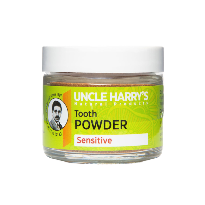 Clear jar of handcrafted Uncle Harry's natural tooth powder for sensitive teeth, featuring a bright green label with warming essential oils, ideal for health remedies and personal hygiene.