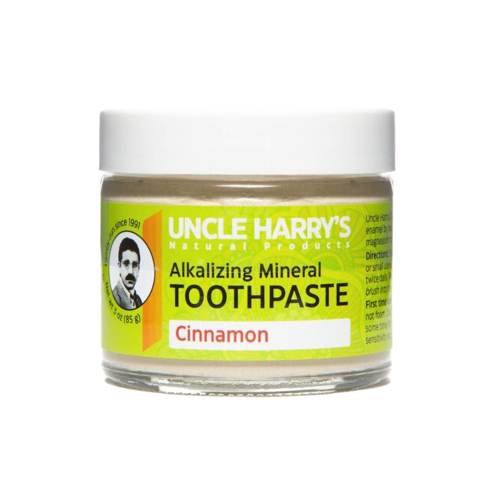 Small glass jar of handcrafted alkalizing mineral toothpaste in cinnamon flavor with a bright yellow label, promoting natural health and wellness and American-made grooming care.