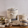 Assortment of handcrafted USA-made stoneware kitchen and food preservation crocks and bowls, including a large 3-gallon crock and smaller fermenting vessels with classic blue stripes.