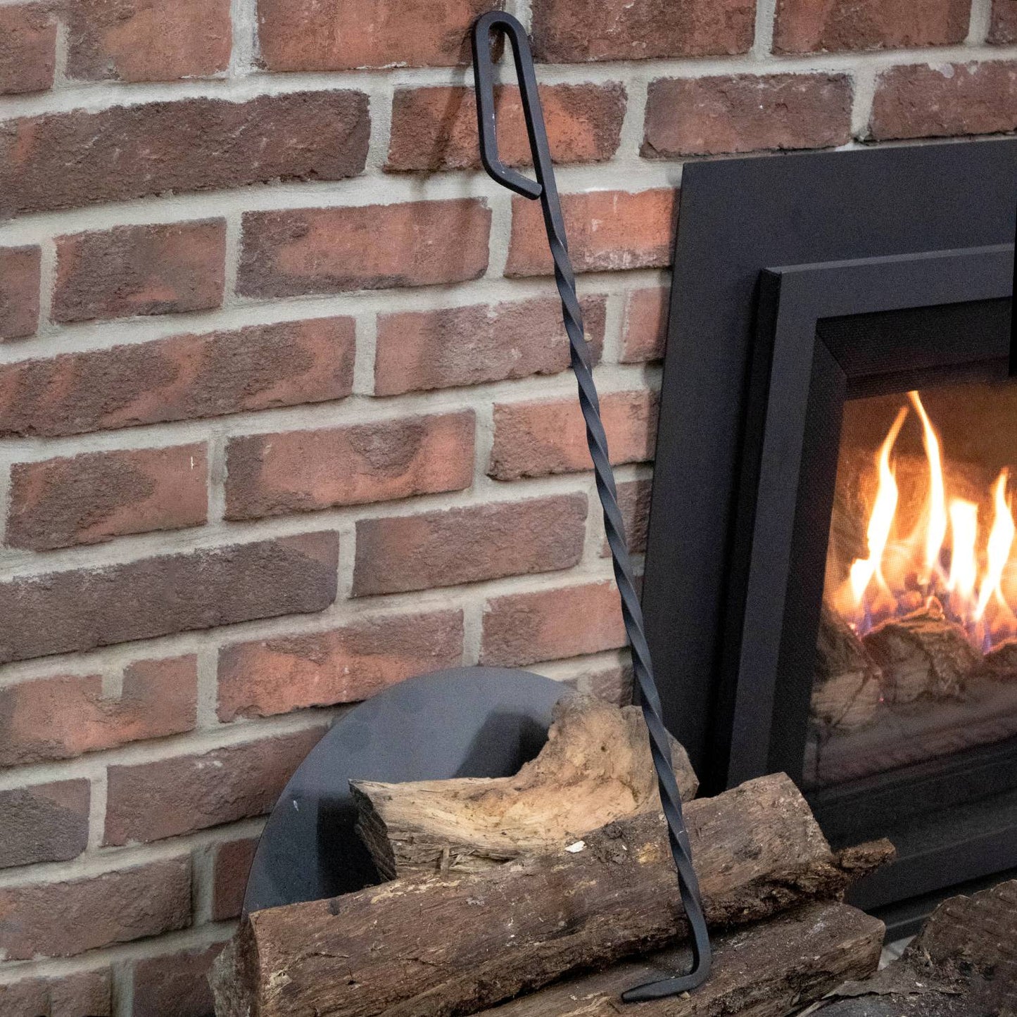 Handcrafted steel fire poker with a loop handle and twisted design, made in USA and Amish crafted, ideal for adjusting logs safely in home fireplaces, featured in Stoves and Hearth Accessories collections.