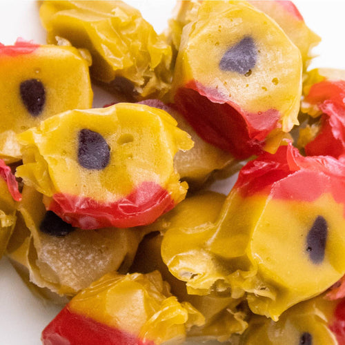 Close-up of colorful homemade hard candy pieces with yellow centers, red edges, and dark spots, evoking classic sweet flavors from Kitchen & Food, Snacks and Sweets, Best Sellers, and Promo Eligible collections.