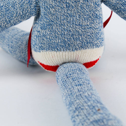 Close-up of the back of a handcrafted blue knit sock monkey made from classic red and white heel socks, featuring a flexible tail, part of USA Made and Children's Toys collections.