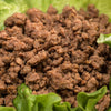 Close-up of cooked canned ground beef served on fresh green lettuce, highlighting its ready-to-use quality, ideal for Kitchen & Food, Meats, Best Sellers, and Promo Eligible collections.