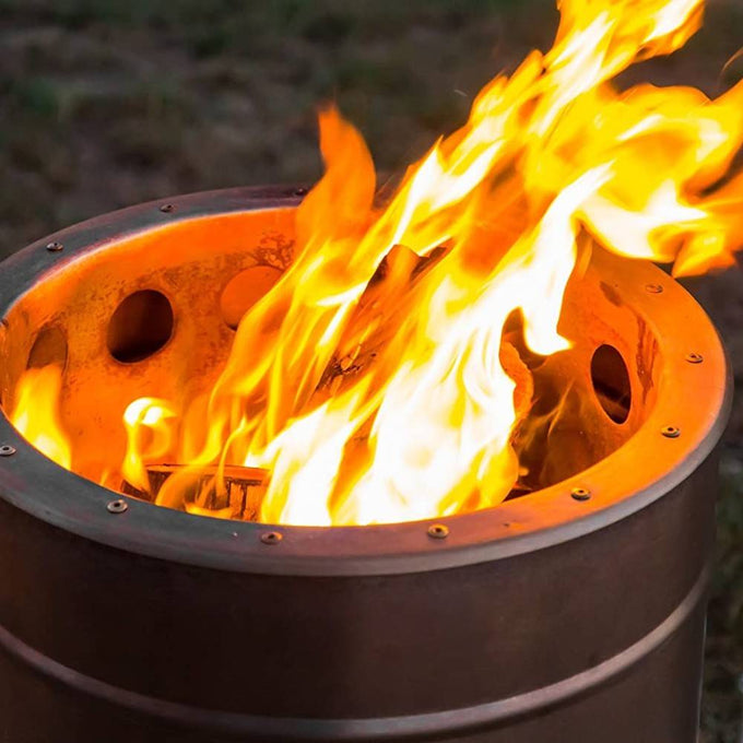 Outdoor fire barrel made of brushed stainless steel with large flames rising through round ventilation holes, perfect for Farm, Garden & Tool, Camping, and Best Sellers collections.