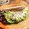 Sandwich made with hearty bread, leafy lettuce, and creamy turkey salad topped with alfalfa sprouts, served on wooden board with fresh grapes and carrots, part of Farm, Garden & Tool, Kitchen & Food, Emergency Supplies, Food, Meats, Best Sellers, Promo Eligible collections.