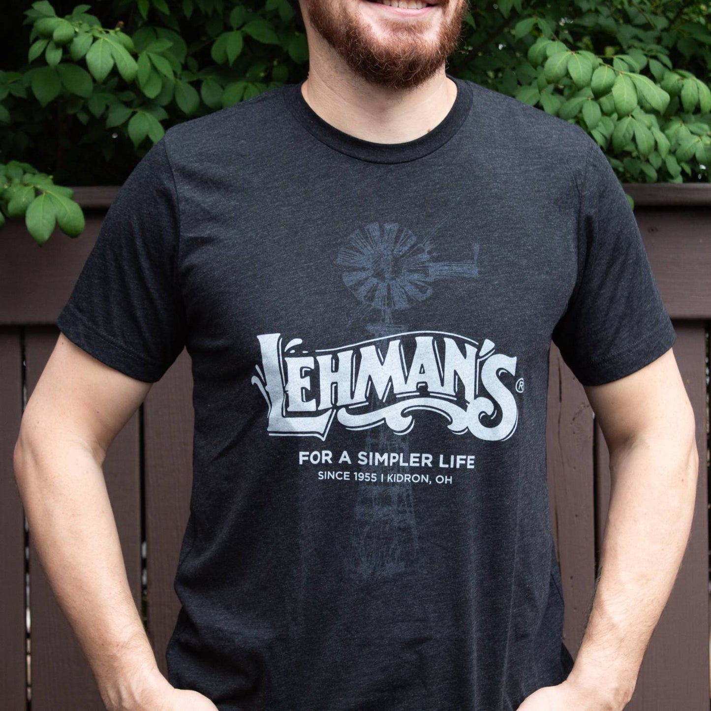 Man wearing a soft, lightweight black t-shirt featuring a subtle windmill graphic and Lehman's logo with "For a Simpler Life" print, ideal for Health & Wellness, Clothing and Accessories, Best Sellers, and Promo Eligible collections.