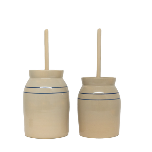 Pair of handcrafted stoneware butter churns in natural stone color with traditional double blue stripes and smooth unfinished wooden dashers, made in USA, featured in Kitchen & Food, Specialty Equipment, Making Butter, USA Made, Best Sellers, and Promo Eligible collections.