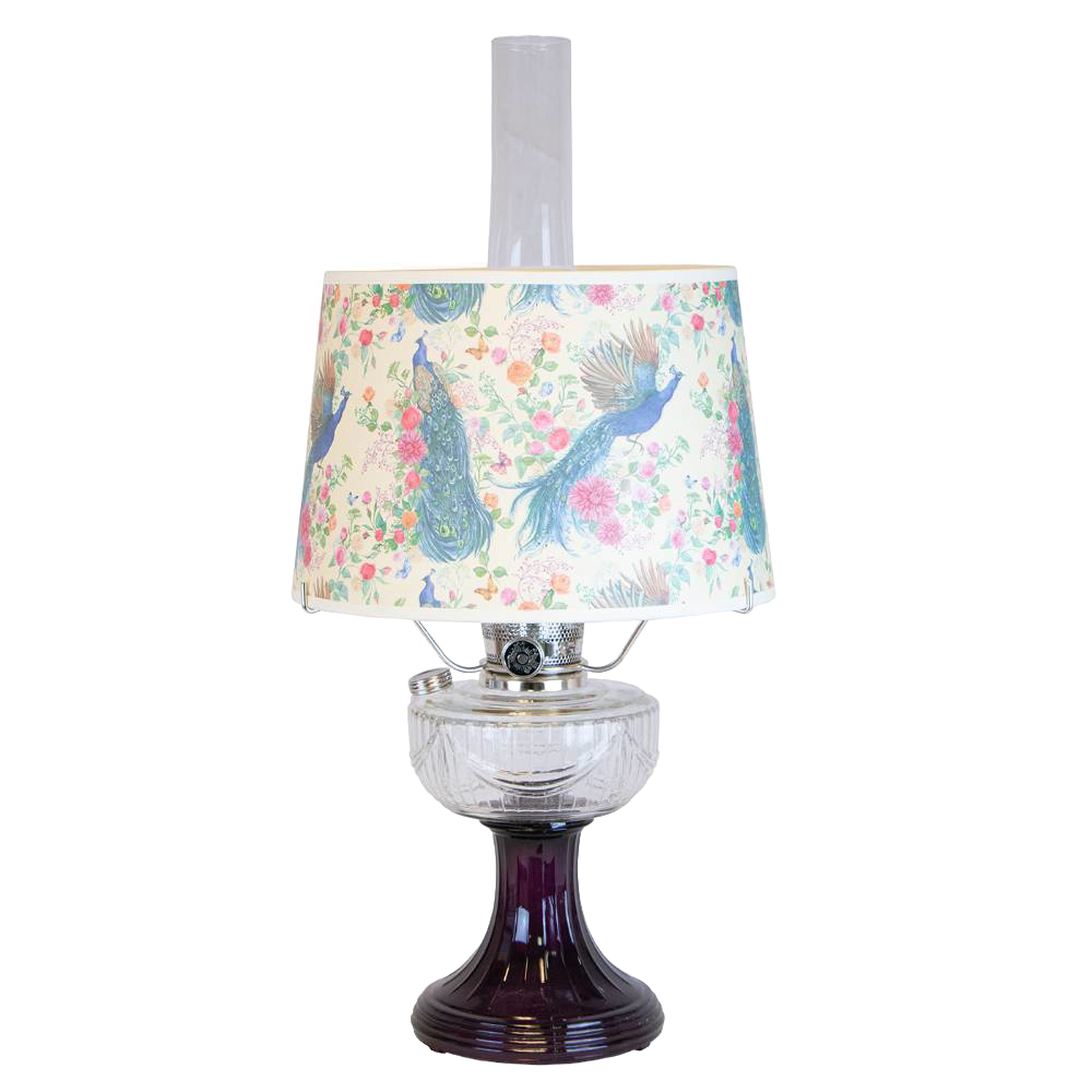 Vintage-style oil lamp with a clear glass bowl over an amethyst pedestal base, featuring a decorative peacock-patterned shade, part of Lamps & Lighting and Best Sellers collections.