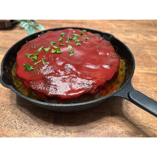 Handcrafted nitrogen-hardened cast iron skillet featuring a cooked dish topped with rich tomato sauce and fresh chopped herbs, ideal for Kitchen & Food, Cookware, Cast Iron, Best Sellers, and Promo Eligible collections.