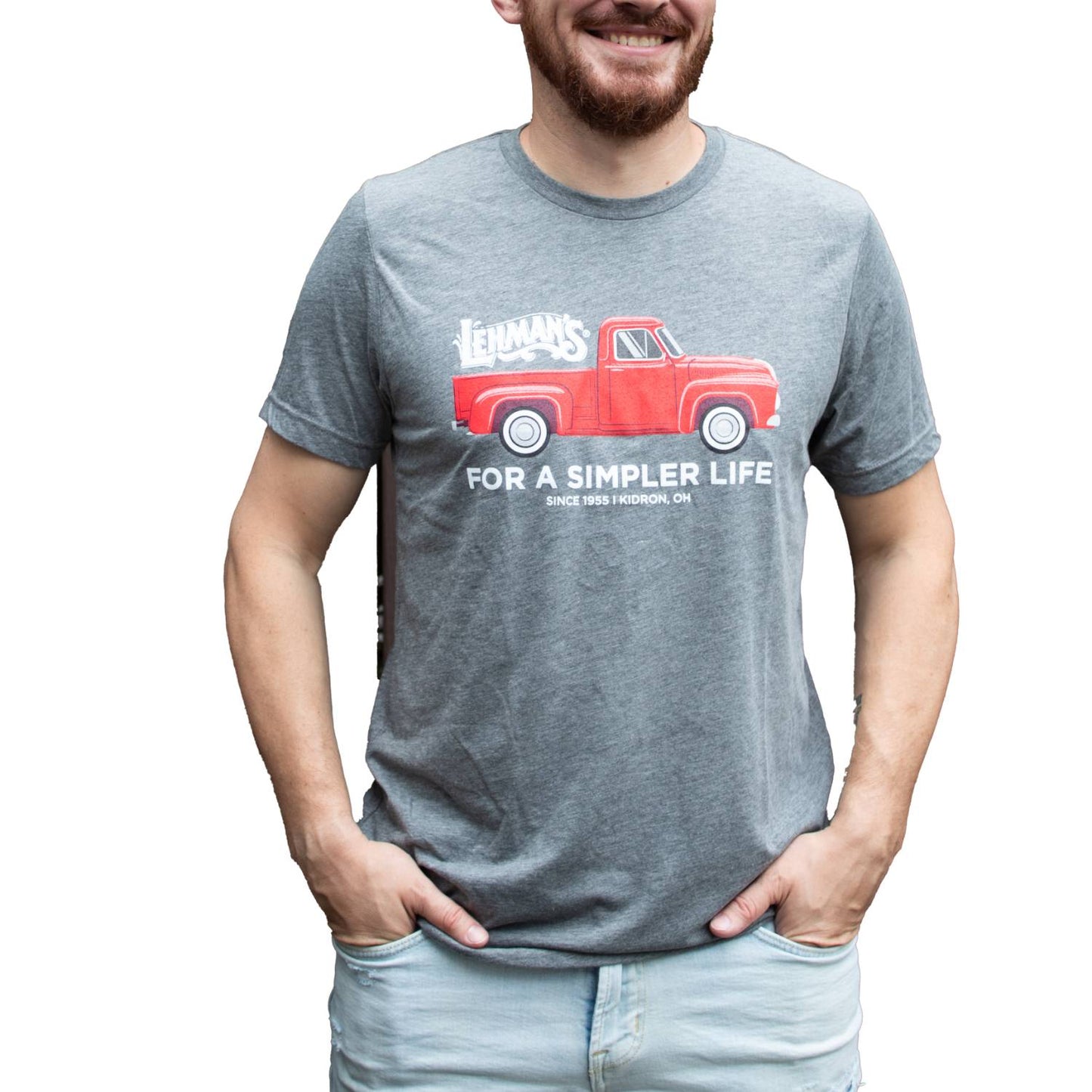 Adult wearing a light gray handcrafted soft cotton t-shirt featuring a vibrant red vintage truck graphic with Lehman's logo and "For a Simpler Life" text, part of Health & Wellness, Clothing and Accessories, Best Sellers, and Promo Eligible collections.