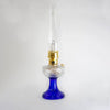 Handcrafted oil lamp with a distinctive cobalt glass base and clear glass font, featuring brass burner trim, offered in Lamps & Lighting, Oil Lamps, Table Lamps, Best Sellers, and Promo Eligible collections.