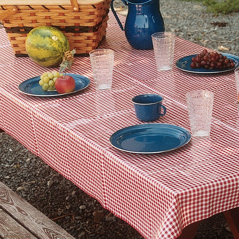 Rectangle vintage vinyl tablecloth in red and white check pattern with durable merrowed edges, styled outdoors with vintage blue enamelware and fresh fruit, ideal for Home & Decor and Kitchen Textiles collections.