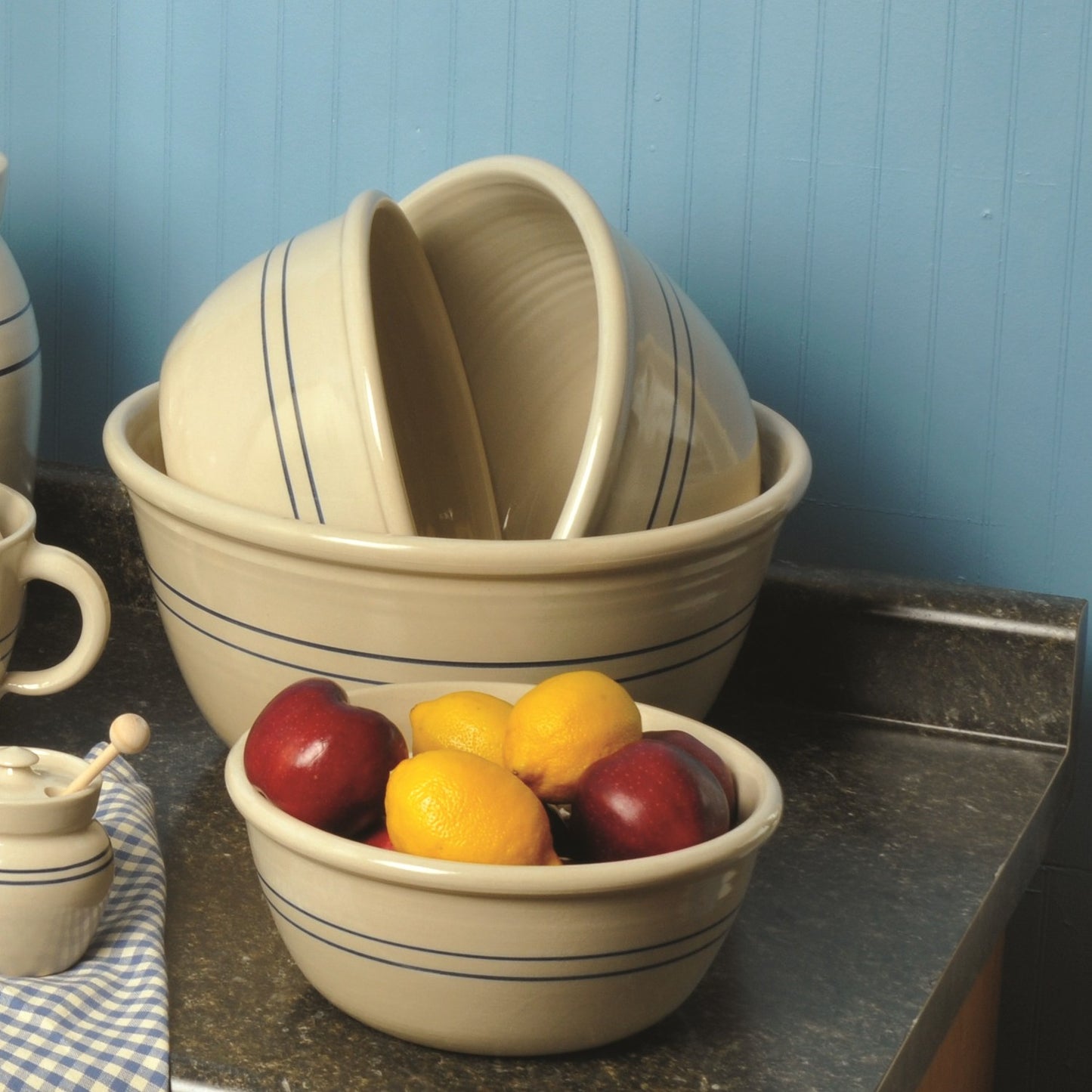 Handcrafted stoneware bowls with heritage blue stripes, made in USA, displayed on kitchen counter with fresh fruit, ideal for Kitchen & Food, Cookware, Baking Supplies, Storage and Serving collections.
