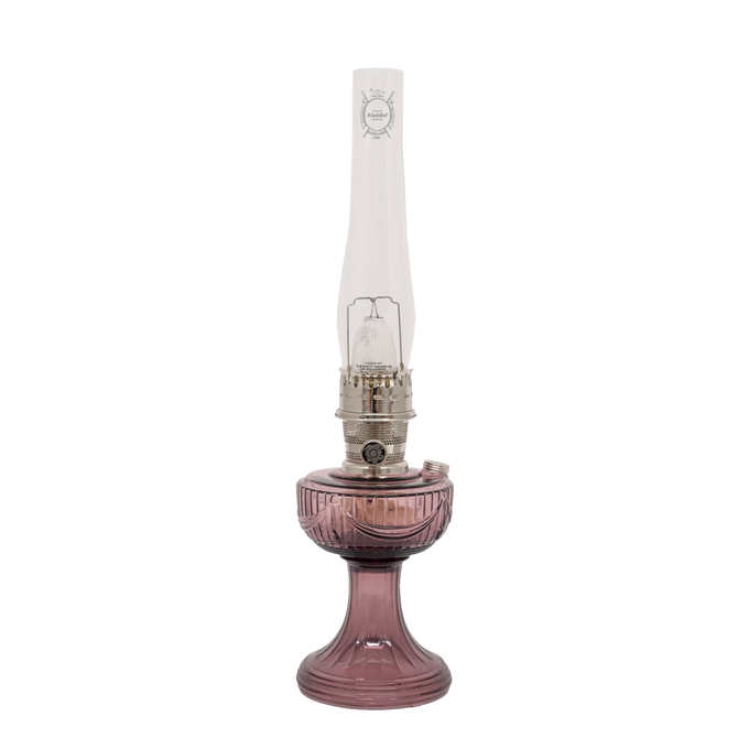 Handcrafted glass oil lamp with a rose-tinted Lincoln Drape base, tall clear chimney bearing embossed logo, and polished brass burner, ideal for Farm, Garden & Tool, Lamps & Lighting, Oil Lamps, Table Lamps, Best Sellers, Homesteading, and Promo Eligible collections.