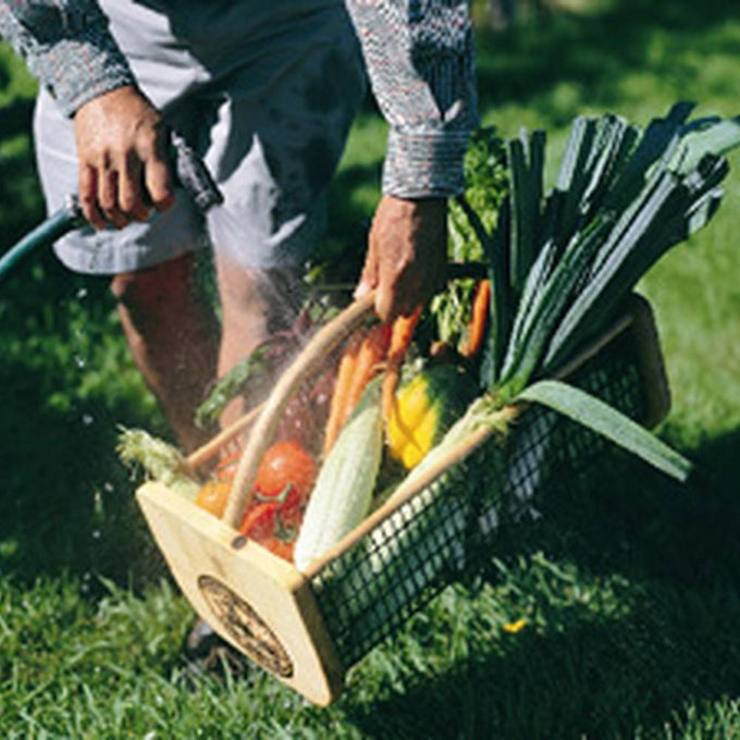 Handcrafted garden hod with smooth wooden ends and wire mesh body, filled with fresh vegetables being rinsed outdoors, part of Farm, Garden & Tool, Garden Accessories, USA Made, Best Sellers, and Promo Eligible collections.