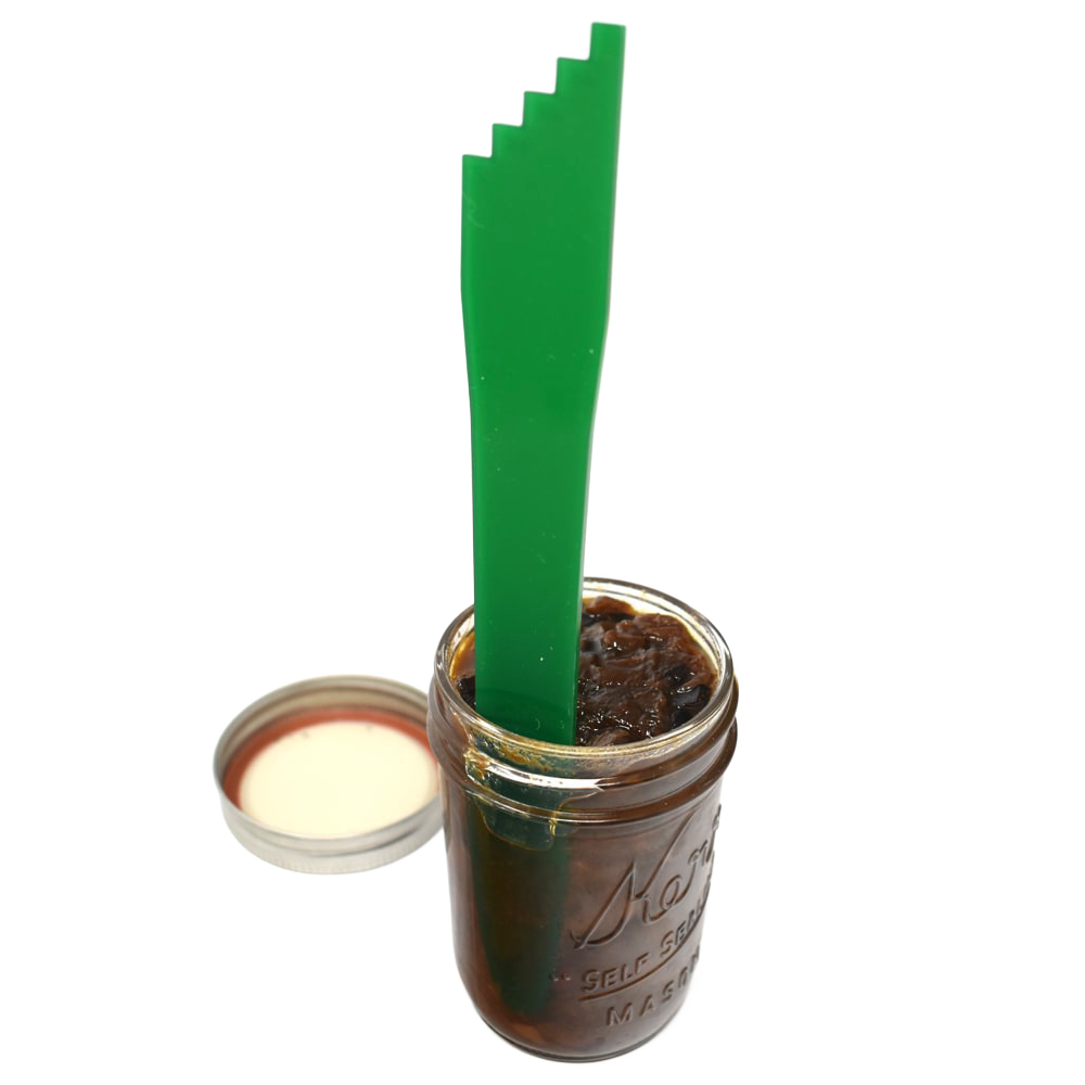 Handcrafted green jar spatula with multiple notch sizes for lifting and adjusting canning jar lids, shown inside a glass canning jar filled with preserves, perfect for Food Preservation, Canning, Kitchen & Food collections.