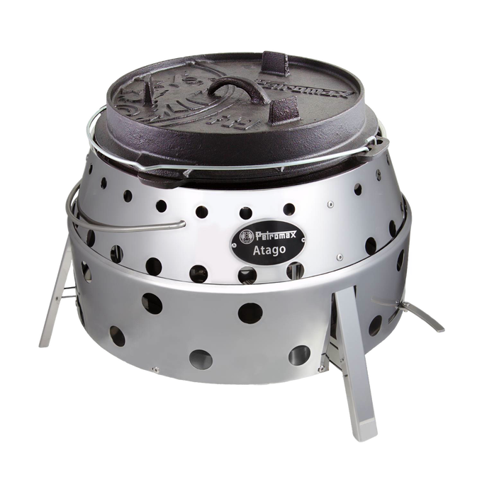Portable stainless steel camp grill and fire bowl with round perforated body and cast iron lid, handcrafted for outdoor grilling, camping, and firepit use.