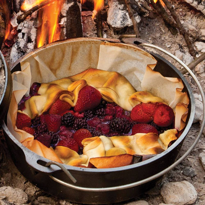Handcrafted cast iron camp Dutch oven baking mixed berry pie with golden crust over an open fire, featured in Farm, Garden & Tool, Camping, Cast Iron, USA Made, Best Sellers, and Promo Eligible collections.