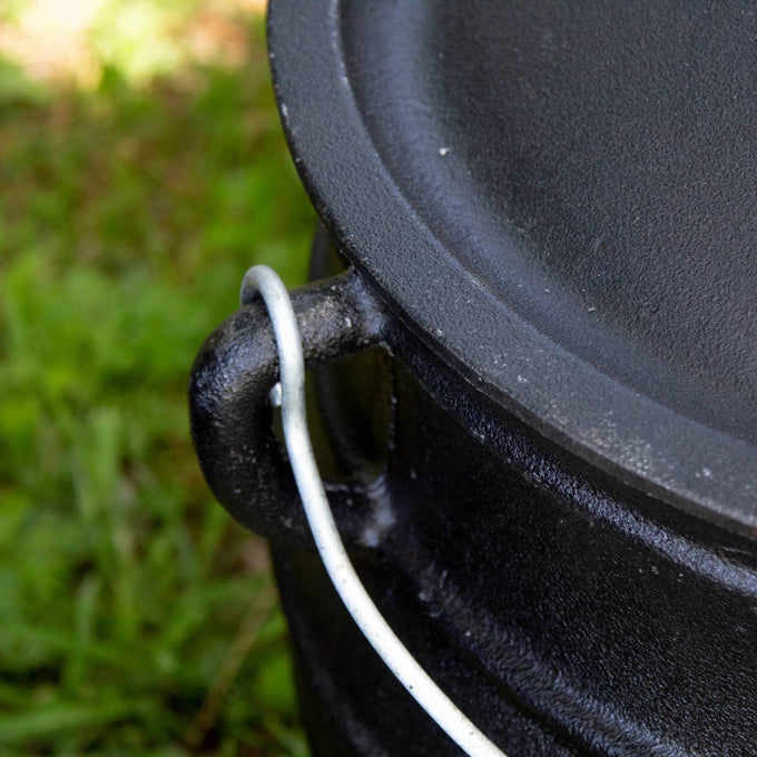 Close-up of a handcrafted cast iron campfire kettle’s sturdy wire bail handle attached to the thick rounded rim, designed for long-lasting outdoor use in Farm, Garden & Tool, Camping, Best Sellers, and Promo Eligible collections.