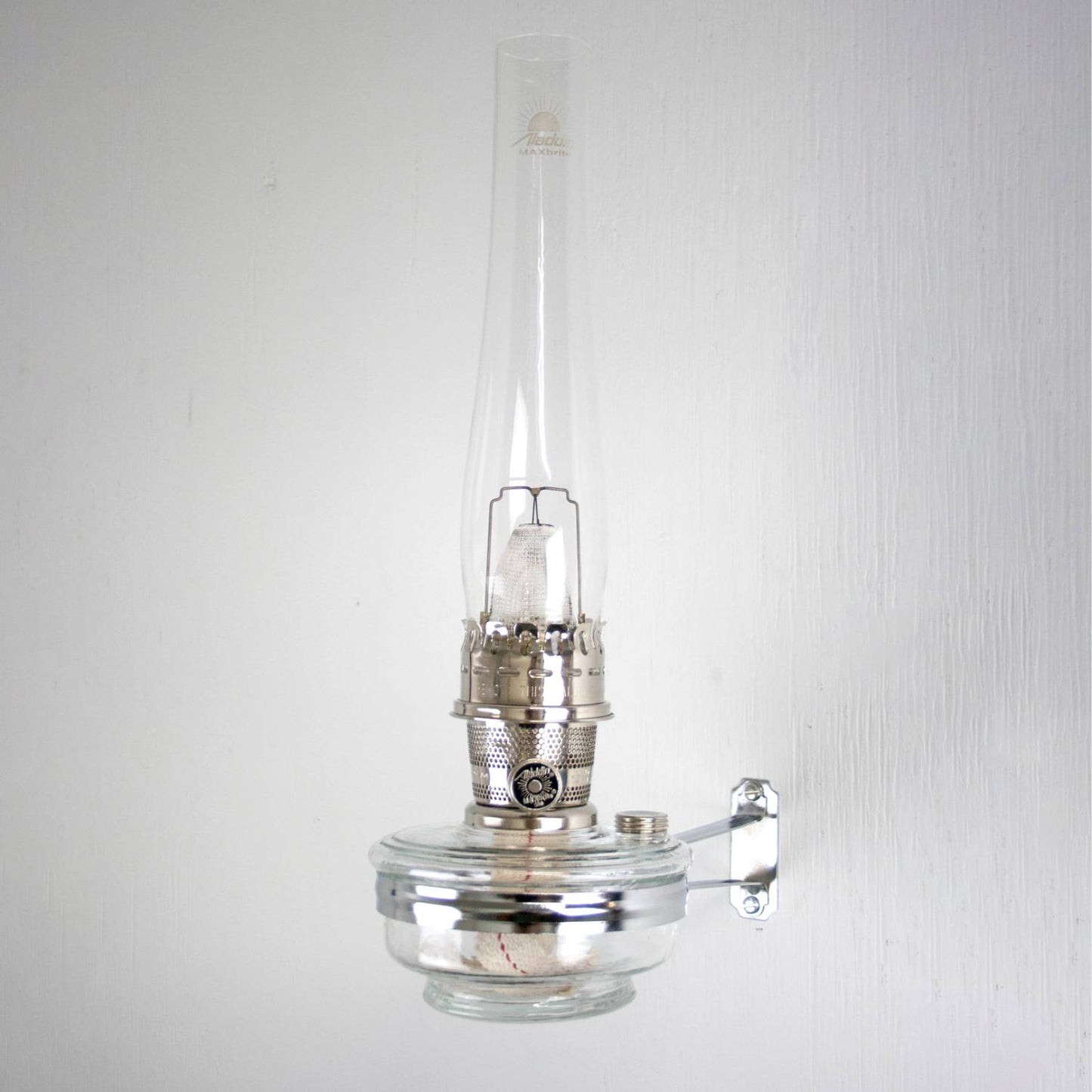 Handcrafted clear glass oil lamp with polished metal burner and wall-mounted bracket, designed for classic Aladdin lamps, featured in Lamps & Lighting, Oil Lamps, Wall Lamps, Best Sellers, and Promo Eligible collections.