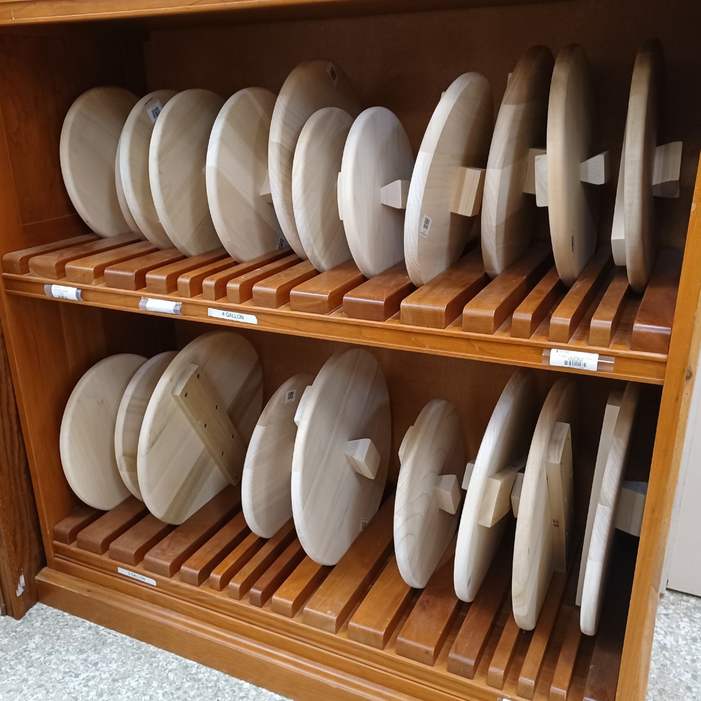 Handcrafted unfinished wooden lids crafted from smooth poplar, arranged neatly on wooden shelves, ideal for food preservation and fermenting in Kitchen & Food and USA Made collections.