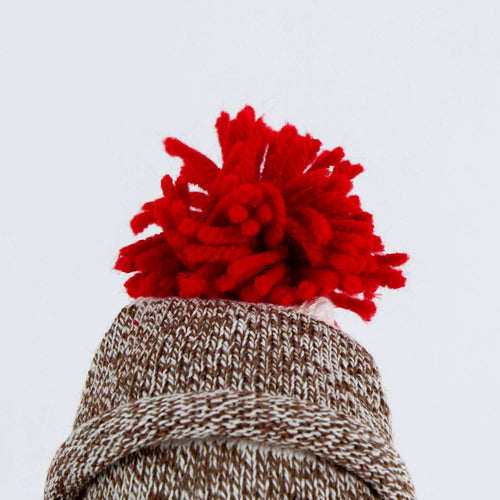 Close-up of a hand-stitched red yarn pom-pom atop a cozy brown and white knit hat, handcrafted in the USA, featured in Toys, Books & Games, USA Made, Children's Toys, Indoor Play, and Best Sellers collections.