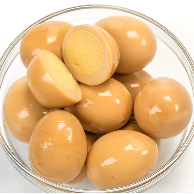 Clear glass bowl filled with glossy brown smoked canned eggs, one halved to reveal firm yolk, ideal for Kitchen & Food, Food, Pantry, USA Made, Best Sellers, and Promo Eligible collections.