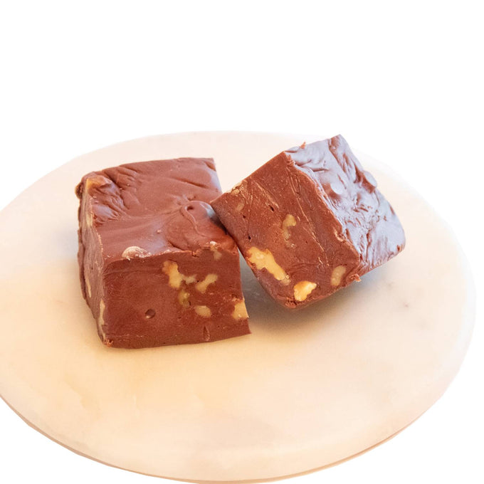 Two handcrafted creamy chocolate fudge squares with crunchy walnut pieces, showcasing a rich, melt-in-your-mouth texture, featured in Kitchen & Food, Snacks and Sweets, USA Made, Best Sellers, and Promo Eligible collections.