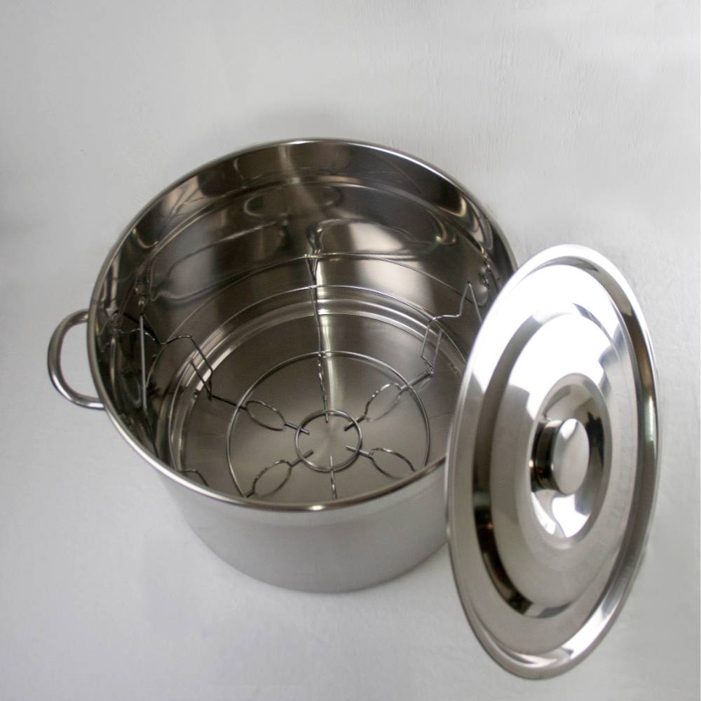 Shiny stainless steel 20-quart canner with lid removed, featuring a sturdy rack inside, designed for water bath canning and versatile kitchen use in food preservation collections.
