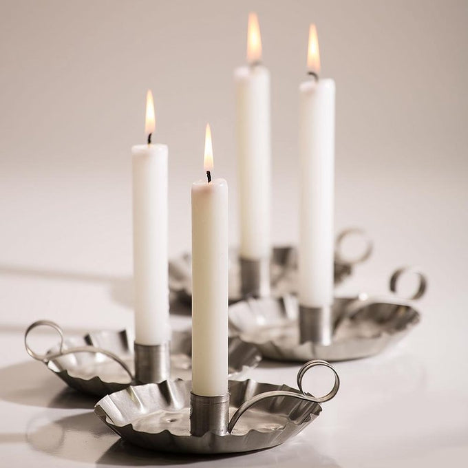 Set of four handcrafted white candles burning brightly in rustic metal holders with ring handles, ideal for Farm, Garden & Tool, Lamps & Lighting, and Emergency Supplies collections.